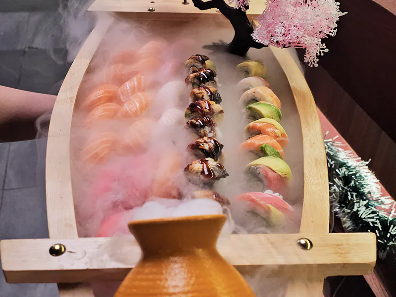 Dramatic wooden boat sushi and roll platter at Pakusan Sushi & Grill, a Japanese Restaurant in Chandler